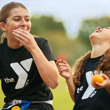 2 girls laughing while playing sports