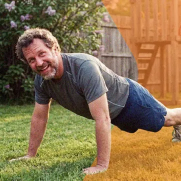 man doing push-ups in his backyard on a sunny day