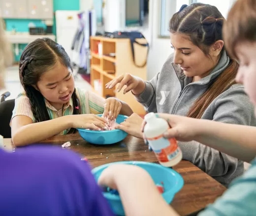Child and YMCA staff member playing with slime