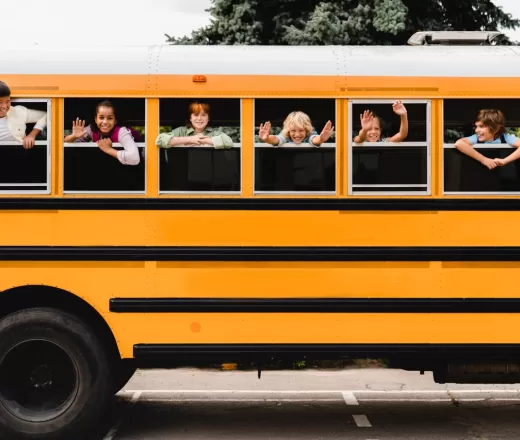 kids waving from school bus