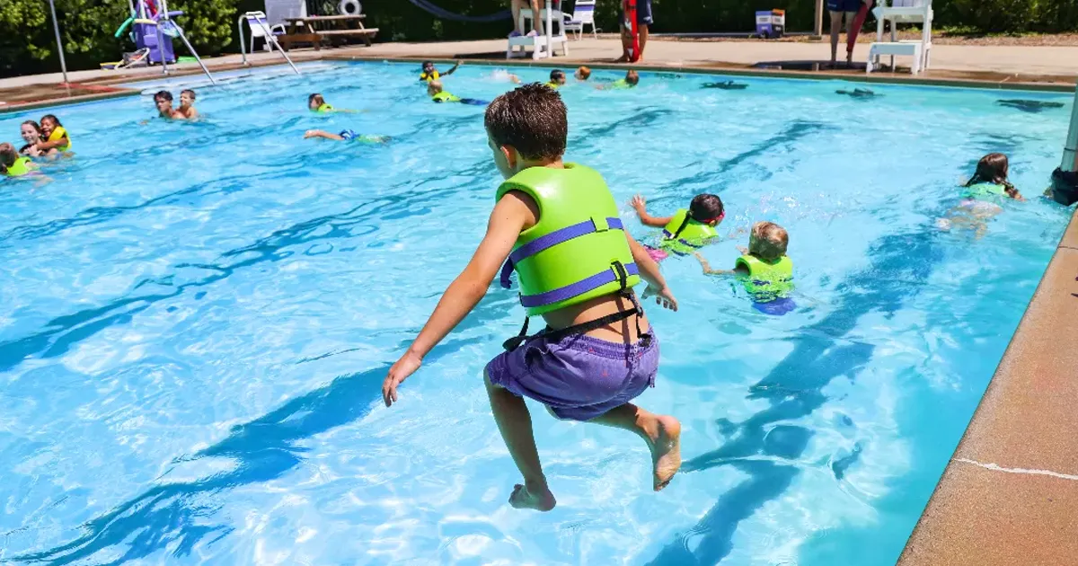 child jumping into a swimming pool