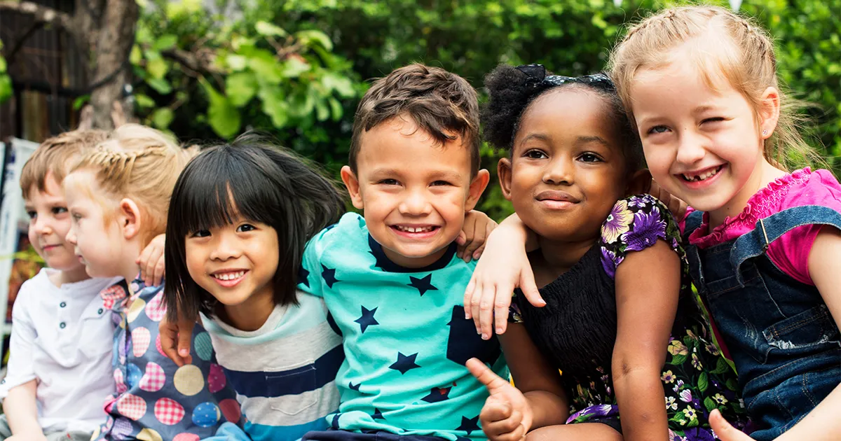 smiling preschoolers with arms around eachother