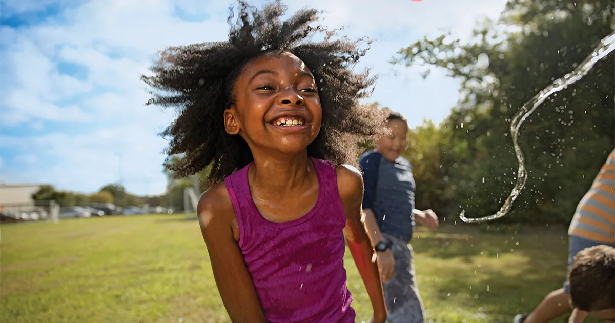 child playing with water outside