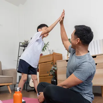 dad and child giving high five after a workout