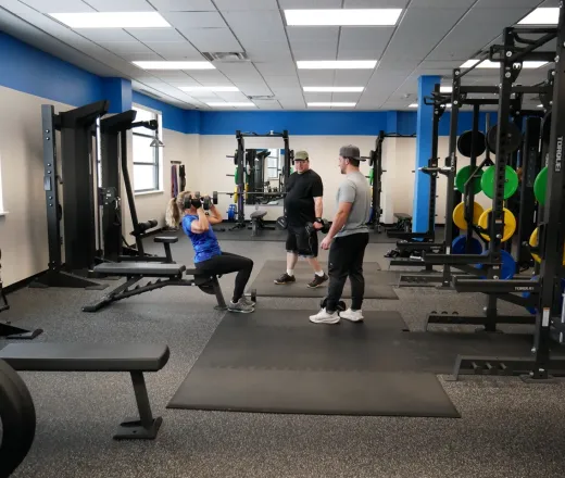YMCA personal trainer and two clients in the fitness center